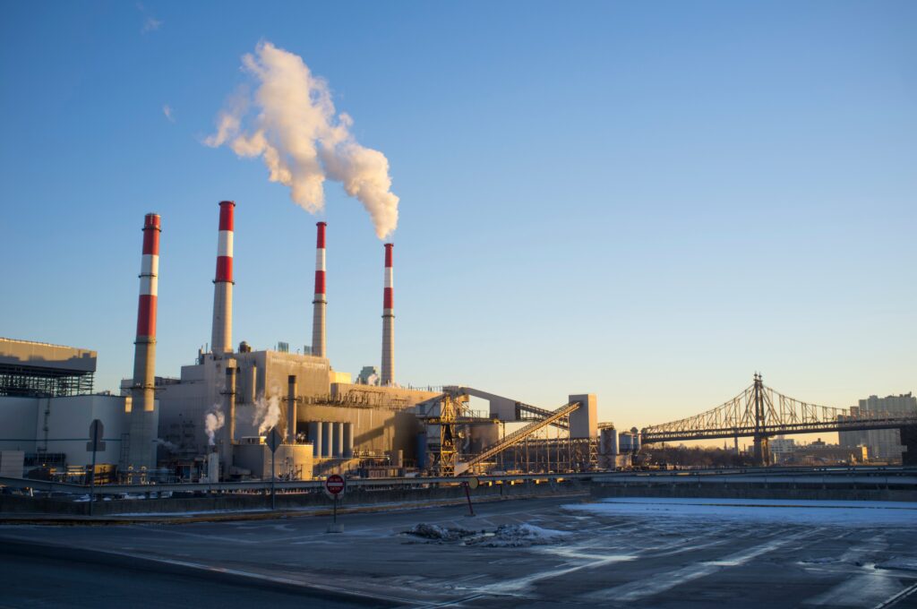 Smoke stacks in factory by bridge, New York, USA